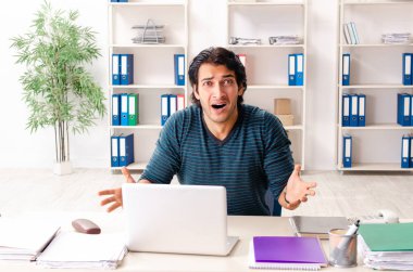 Ofiste oturan genç yakışıklı erkek çalışan