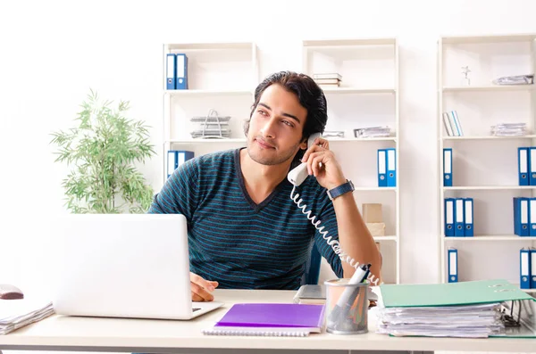 Ung snygg manlig anställd sitter på kontoret — Stockfoto