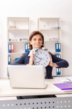 Ofiste oturan orta yaşlı kadın işçiye  