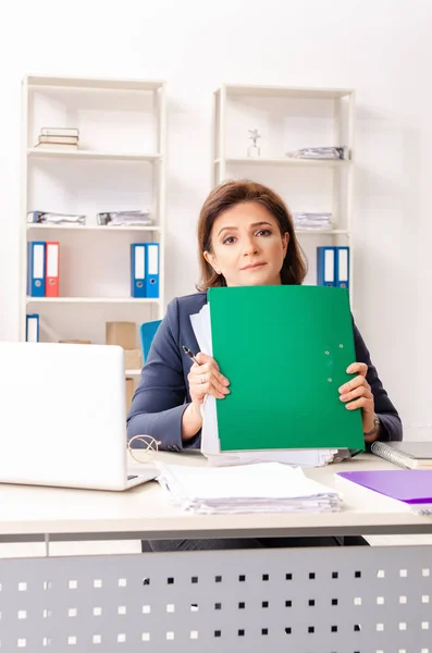 Empregada feminina de meia-idade sentada no escritório — Fotografia de Stock