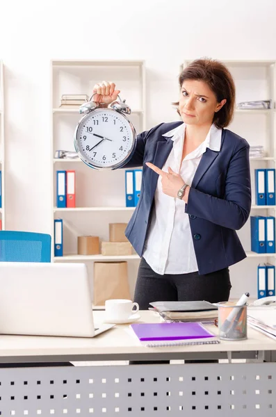 Empleada de mediana edad sentada en la oficina —  Fotos de Stock