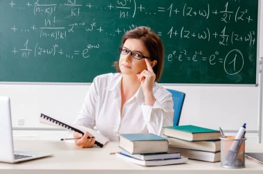 Kara tahta önünde kadın matematik öğretmeni 
