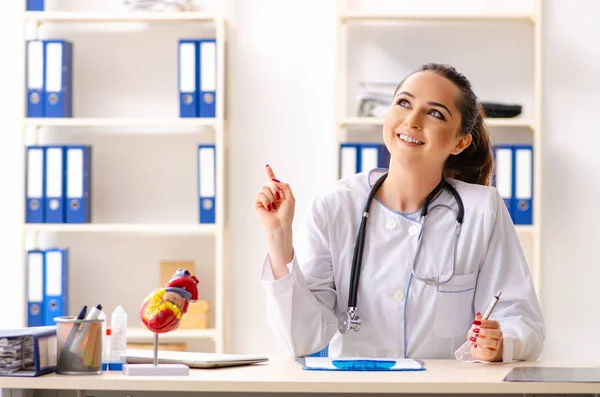 Mujer joven médico cardiólogo sentado en el hospital — Foto de Stock