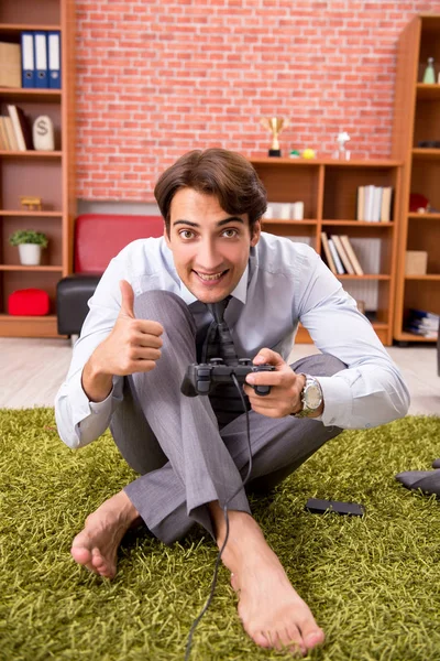 Jonge werknemer speelt joystick games tijdens zijn pauze — Stockfoto