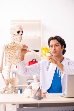 İskeleti olan genç erkek doktor. 