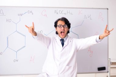 Beyaz tahta önünde genç komik kimyager 