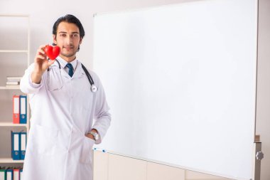 Genç doktor beyaz tahtanın önünde. 