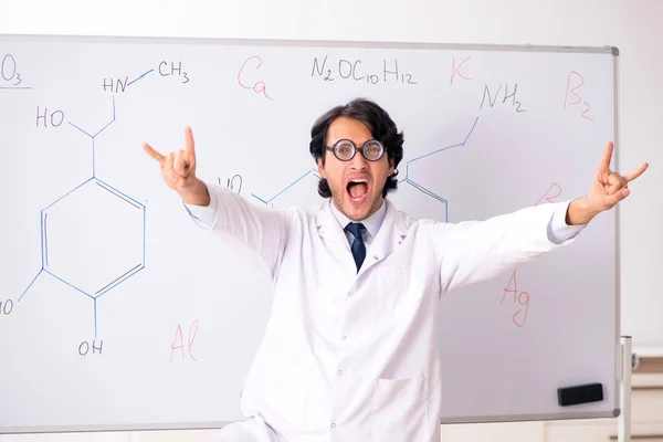 Young funny chemist in front of white board — Stock Photo, Image