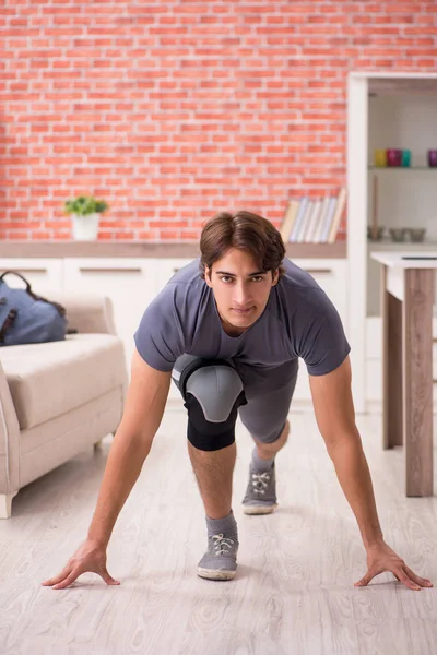 Young handsome man doing sport exercises at home — Stock Photo, Image