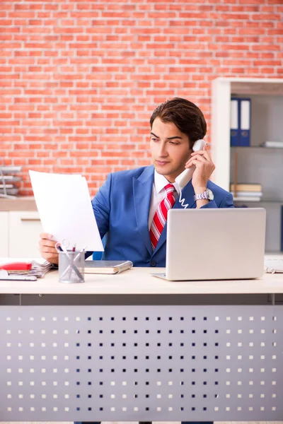 Joven empleado guapo que trabaja en la oficina — Foto de Stock