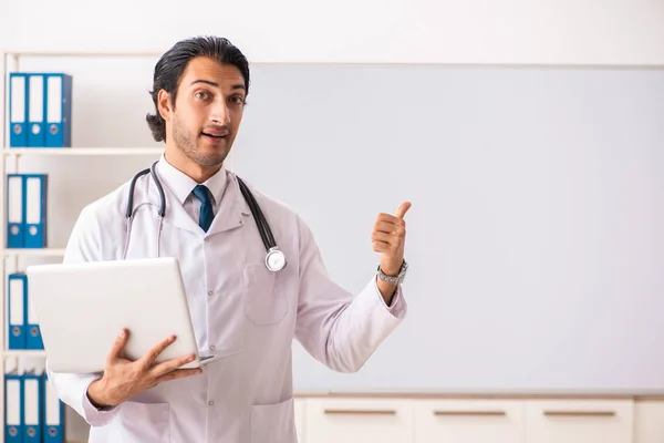 Ung läkare framför whiteboard — Stockfoto
