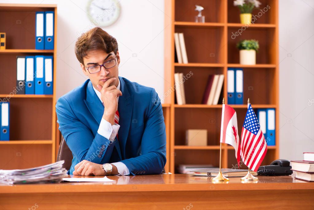 Young handsome politician sitting in office 