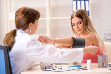 Genç ve güzel bir kadın tansiyon için doktoru ziyaret ediyor. 