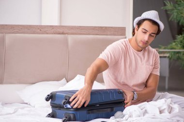 Bavul seyahat için bekleyen yatak odasında olan adam 