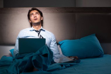 Yorgun işadamı gece fazla mesai yapıyor.