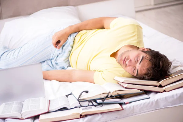 Young student studying in bed for exams — Stock Photo, Image