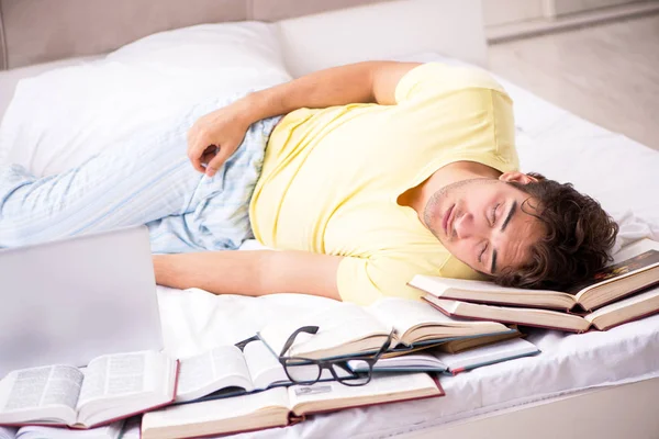 Junge Studentin studiert im Bett für Prüfungen — Stockfoto