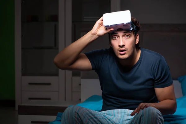 Jovem jogando jogos de computador à noite na cama — Fotografia de Stock