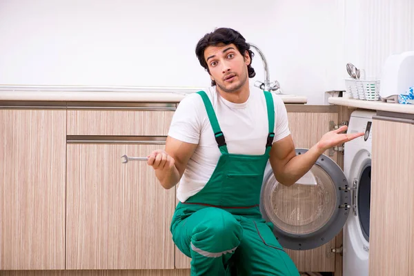 Молодий підрядник ремонтує пральну машину на кухні — стокове фото