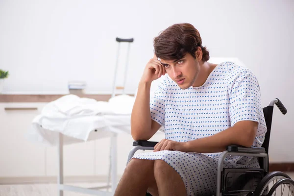 Jonge knappe man in rolstoel in het ziekenhuis — Stockfoto