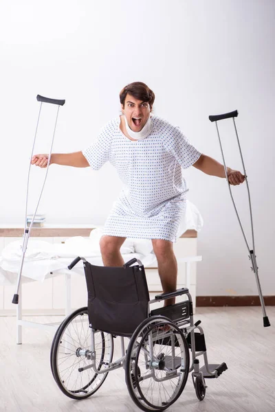Młody przystojny człowiek na wózku inwalidzkim w szpitalu — Zdjęcie stockowe