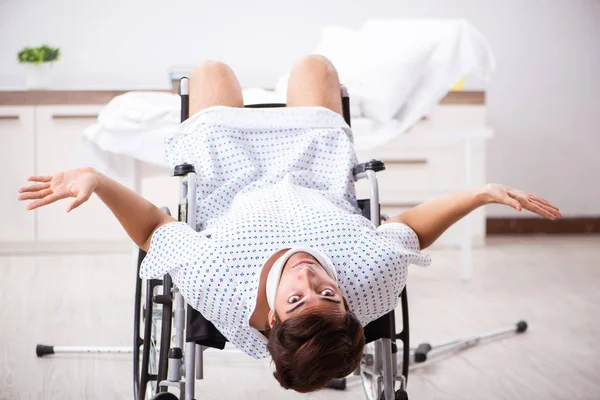 Junger schöner Mann im Rollstuhl im Krankenhaus — Stockfoto