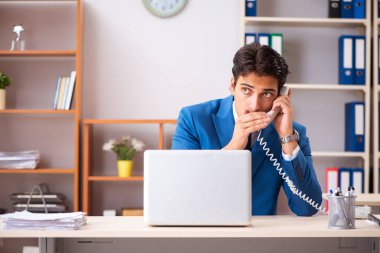 Genç yakışıklı işadamı ofiste çalışıyor. 