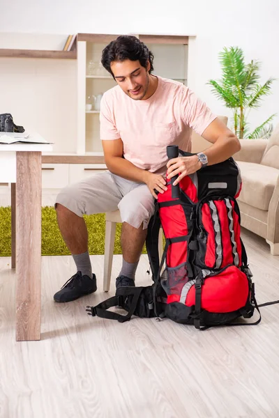 Joven turista masculino preparándose para el viaje en casa — Foto de Stock