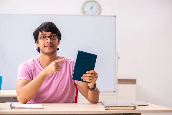 Joven estudiante masculino sentado en la clase — Foto de Stock