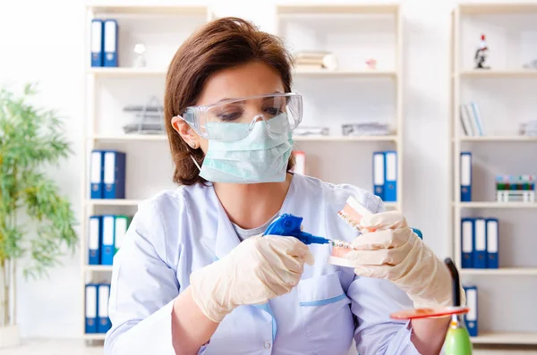 Женщина-врач работает над новым имплантатом зубов — стоковое фото