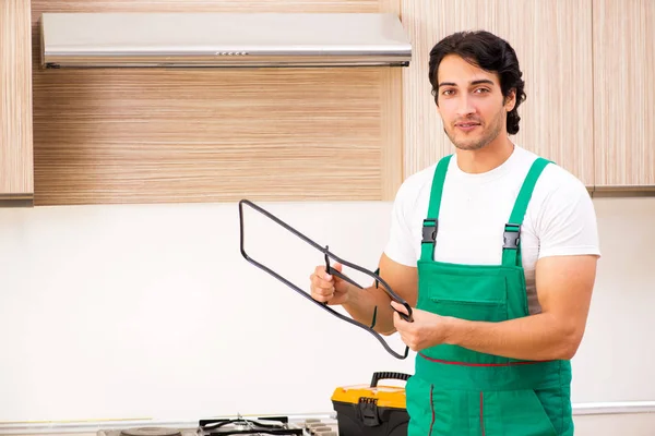 Fiatal vállalkozó javítás sütő a konyhában — Stock Fotó