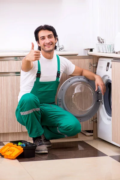 Młodzi wykonawcy naprawy pralkę w kuchni — Zdjęcie stockowe