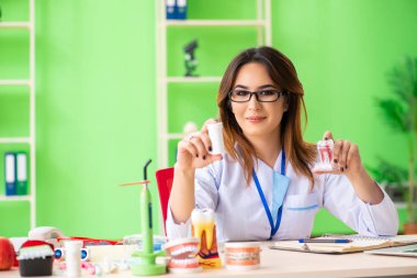 Diş implantı üzerinde çalışan kadın dişçi.