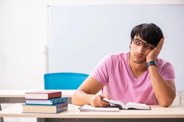 Jovem estudante do sexo masculino sentado na classe — Fotografia de Stock