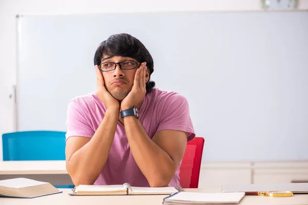 Młody student mężczyzna siedzi w klasie — Zdjęcie stockowe