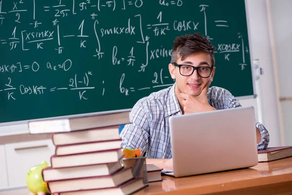 Ung mannlig student som studerer matte på skolen – stockfoto