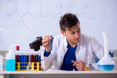 Laboratuarda oturan genç kimyager 