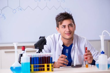 Laboratuarda oturan genç kimyager 