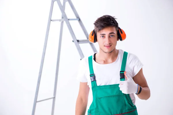 Trabajador joven con orejeras en concepto de cancelación de ruido — Foto de Stock