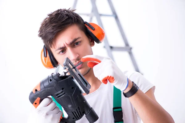 Trabajador joven con orejeras en concepto de cancelación de ruido — Foto de Stock