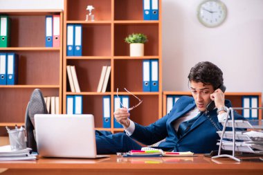 Genç yakışıklı işadamı ofiste çalışıyor.