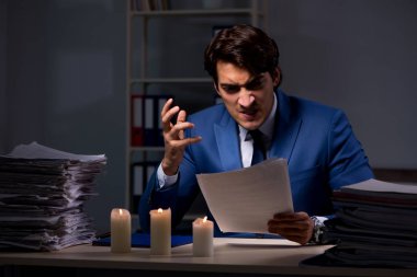 Geç saatlere kadar ofiste mum ışığı ile işadamı