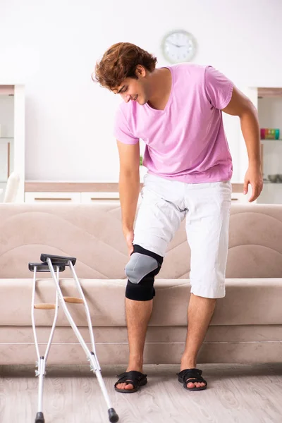Jovem com joelho lesionado se recuperando em casa — Fotografia de Stock