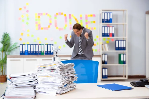 Jovem e bonito empregado sentado no escritório — Fotografia de Stock