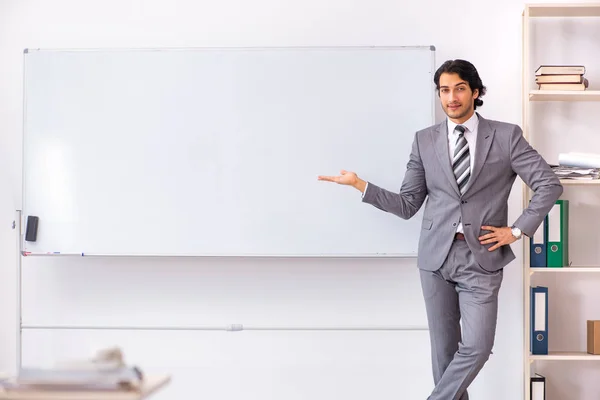 Jonge knappe zakenman staande voor whiteboard — Stockfoto