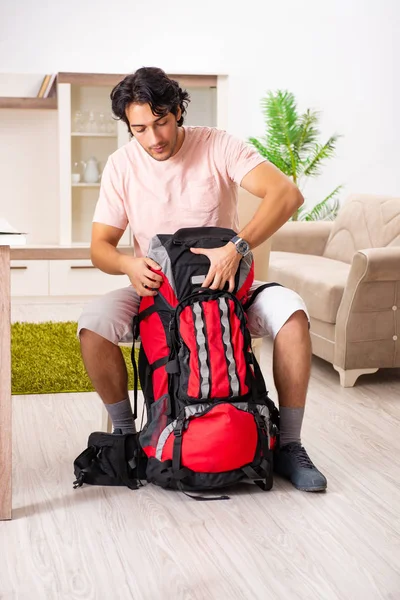 Joven turista masculino preparándose para el viaje en casa — Foto de Stock