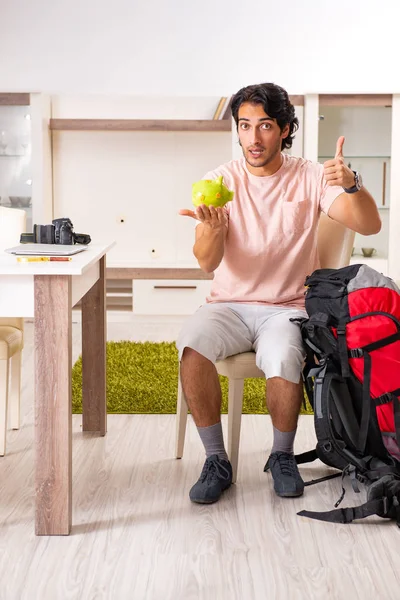 Joven turista masculino preparándose para el viaje en casa — Foto de Stock