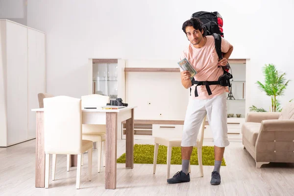 Joven turista masculino preparándose para el viaje en casa — Foto de Stock