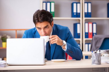 Genç yakışıklı işadamı ofiste çalışıyor. 