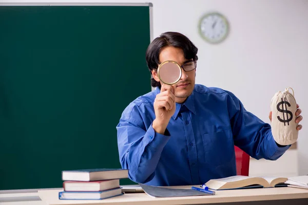 Young male teacher in front of chalkboard — Stock Photo, Image